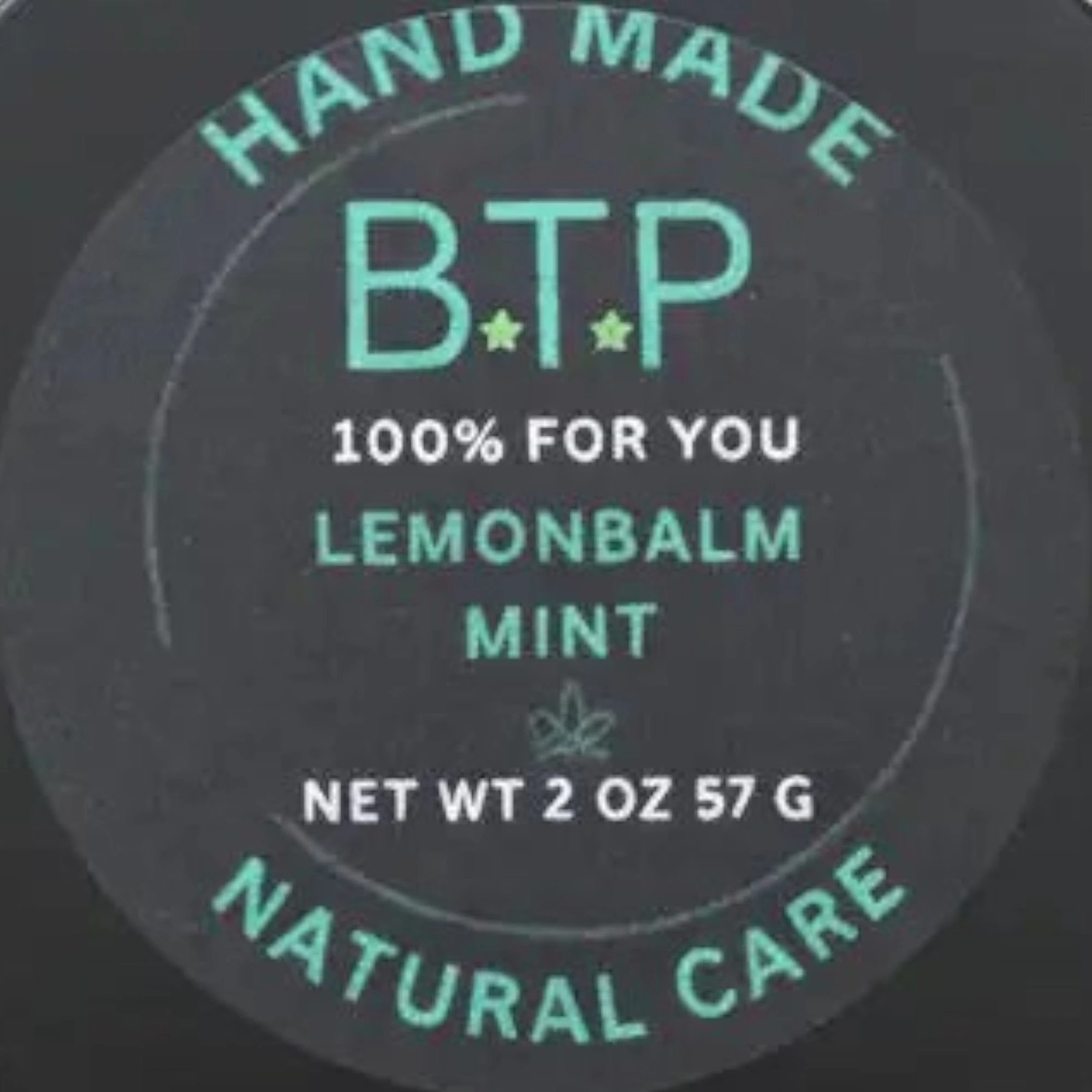 Infinite Storefront Btp Lemon Balm Mint body balm in a 2 oz black tin with a minimalist green and black label.